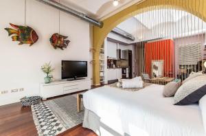 a bedroom with a large bed and a flat screen tv at Sweet Inn - Loft Villa Olimpica Beach in Barcelona