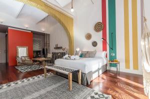 バルセロナにあるSweet Inn - Loft Villa Olimpica Beachの白いベッドとカラフルな壁が備わるベッドルーム1室が備わります。