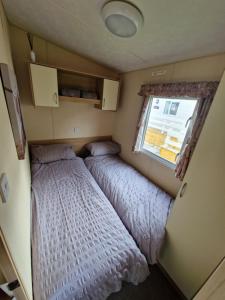 - 2 lits dans une petite chambre avec fenêtre dans l'établissement Taylor's Highland Escape, Dornoch, à Dornoch
