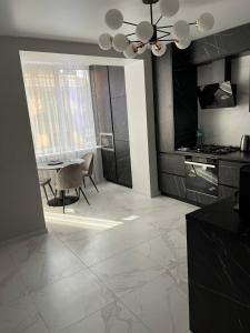 eine Küche mit einem Tisch und einem Esszimmer in der Unterkunft Апартаменти Люкс3 зі світлом in Chmelnyzkyj