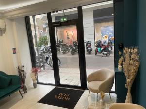 Habitación con puerta de cristal con silla y motocicletas en Hôtel P.L.M. en Cannes