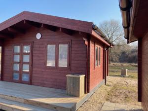 een klein houten huisje met een houten terras bij WOMOCAMP Holzhütte 1 in Saulkrasti