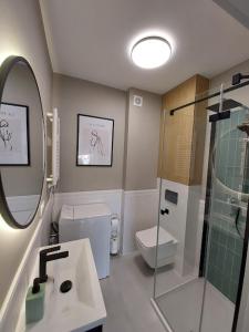 a bathroom with a shower and a toilet and a sink at Apartament Olive Rewal z dostępem do basenu in Rewal