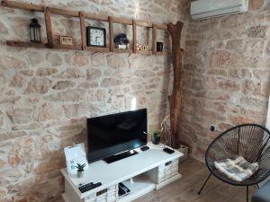 Drinovci的住宿－Šimun&Jakov，一间客厅,在石墙上配有电视