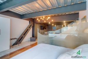 - une chambre avec un lit et un escalier dans l'établissement Cozy & Vibrant Loft with Rooftop & Gym in Polanco, à Mexico