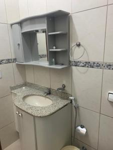 La salle de bains est pourvue d'un lavabo et d'un miroir. dans l'établissement Casa de Veraneio, à Maricá