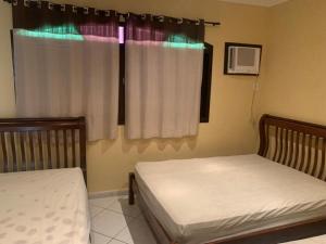 a bedroom with two beds and a window at Casa de Veraneio in Maricá