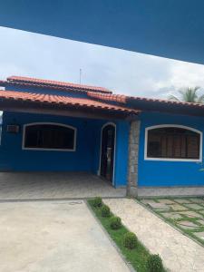 a blue house with a driveway in front of it at Casa de Veraneio in Maricá