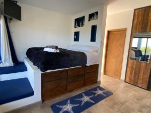 een slaapkamer met een bed met een zwarte deken bij Casa Arrecife - Cozy Suite, Fast Wifi & Balcony! Beach is steps away! in La Ventana