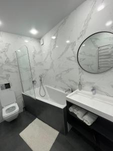 a bathroom with a tub and a toilet and a mirror at Апартаменти Люкс3 зі світлом in Khmelnytskyi