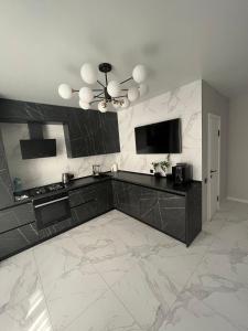 a kitchen with black and white marble floors and a television at Апартаменти Люкс3 зі світлом in Khmelnytskyi