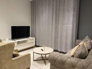 a living room with two chairs and a flat screen tv at Lovely and Cosy 2 bedrooms Space in Rosebank in Johannesburg