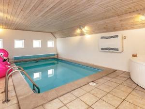 uma piscina num quarto com uma banheira e um WC em 8 person holiday home in Bl vand em Blåvand