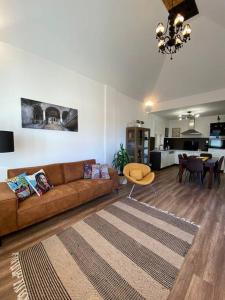 Hillside Apartman في دوناسزينتميكلوس: غرفة معيشة مع أريكة بنية وطاولة