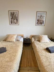 2 Betten nebeneinander in einem Zimmer in der Unterkunft Hillside Apartman in Dunaszentmiklós