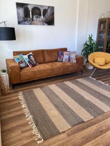 Sofá marrón en la sala de estar con alfombra en Hillside Apartman, en Dunaszentmiklós