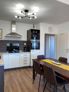 a kitchen and dining room with a table and chairs at Hillside Apartman in Dunaszentmiklós