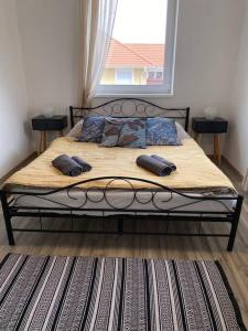 ein Bett mit zwei Kissen darauf in einem Schlafzimmer in der Unterkunft Hillside Apartman in Dunaszentmiklós