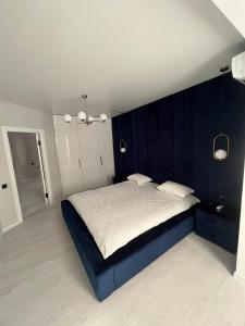 Schlafzimmer mit einem großen Bett mit blauem Kopfteil in der Unterkunft Апартаменти Люкс3 зі світлом in Chmelnyzkyj