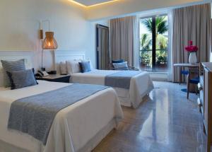 Fiesta Americana Puerto Vallarta All Inclusive & Spa في بويرتو فايارتا: غرفة فندقية بسريرين ونافذة كبيرة