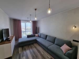 a living room with a blue couch and a television at Dream Town,залізничний вокзал in Lutsk