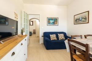 a living room with a blue couch and a television at Appartamento Ogliastra in Santa Maria Navarrese