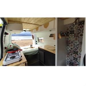 an rv with a kitchen and a stove in it at Sleepfurgo in Las Palmas de Gran Canaria