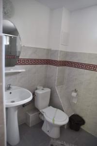 łazienka z toaletą i umywalką w obiekcie Pensiunea sellina w mieście Sulina