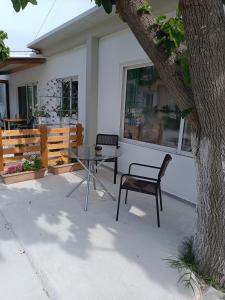 a patio with a table and a chair next to a tree at Studio Evridiki in Georgioupolis