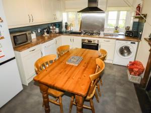 a kitchen with a wooden table and chairs at Tyn Y Ffynnon in Betws-y-coed