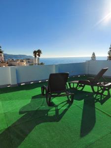 two chairs and a table on a balcony with the ocean at 2ºA Escobar in Nerja
