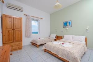 a bedroom with two beds and a window at Psili Ammos Studios in Aliko Beach +19 photos
