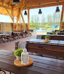 a pavilion with wooden tables and benches and potted plants at Marina Niedźwiedzi Róg in Ruciane-Nida