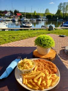 a plate of food with french fries on a table at Marina Niedźwiedzi Róg in Ruciane-Nida