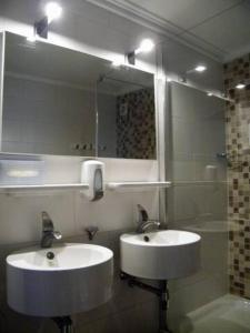 bagno con 2 lavandini e specchio di Studio bed & Strand a Scharendijke