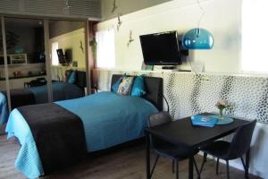 Schlafzimmer mit einem Bett, einem Tisch und einem TV in der Unterkunft Studio bed & Strand in Scharendijke