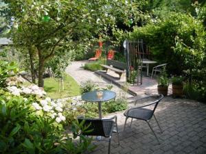 un patio con tavolo, sedie e panca di Studio bed & Strand a Scharendijke