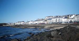 un grupo de casas en la orilla de una playa en Enfield Street house behind Portstewart promenade with partial sea view from front 3 bed sleeps 7, en Portstewart