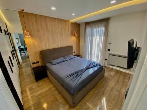 a bedroom with a bed and a television in it at Lux Apartment 02 + Free Parking Post in Tirana