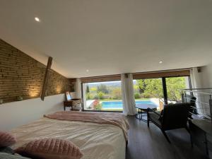een slaapkamer met een bed en uitzicht op een zwembad bij Domaine de Quintalone in Cintegabelle