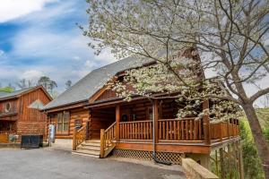 a log cabin with a porch and a deck at 2-Bedroom Cabin with 2 Master Suites, Loft, Half-Bath and hot tub in a Serene Resort Setting in Sevierville