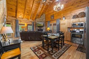 een keuken en eetkamer met een tafel en stoelen bij 2-Bedroom Cabin with 2 Master Suites, Loft, Half-Bath and hot tub in a Serene Resort Setting in Sevierville