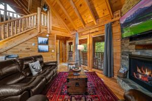 ein Wohnzimmer mit einem Ledersofa und einem Kamin in der Unterkunft 2-Bedroom Cabin with 2 Master Suites, Loft, Half-Bath and hot tub in a Serene Resort Setting in Sevierville