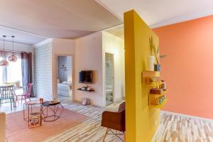 バルセロナにあるSweet Inn - Charming in Sant Gervasiのオレンジの壁と黄色の壁のリビングルーム