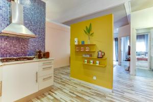 a kitchen with a yellow wall and white cabinets at Sweet Inn - Charming in Sant Gervasi in Barcelona