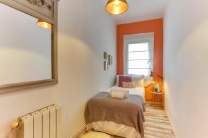 um pequeno quarto com uma cama e um espelho em Sweet Inn - Charming in Sant Gervasi em Barcelona
