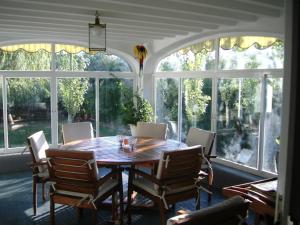 a dining room with a table and chairs and windows at alojamiento temporal El Sotillo in Cuenca