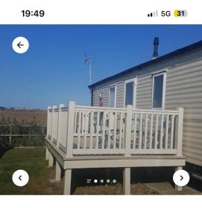 a house with a white railing on a deck at Luxury 8 and 6 berth caravans in Jaywick Sands