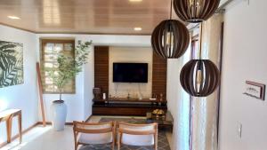 a living room with a tv and a table and chairs at Casa Charme de Lençois in Lençóis