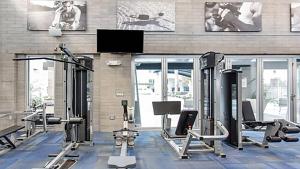 a gym with several tread machines and a flat screen tv at Loft with Views-King Beds-Shop & Dine-1mi & Parking 4058 in Phoenix